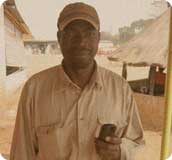 A man using a cellphone in rural Africa